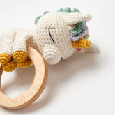 Side view of crocheted unicorn baby rattle showing details of mane and horn